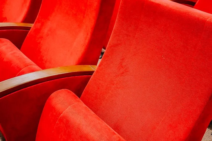 Classic vintage movie theater with red velvet seats and illuminated screen
