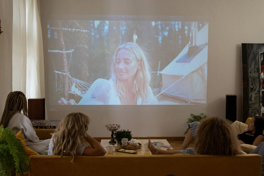 A movie playing from a projector onto a living room wall