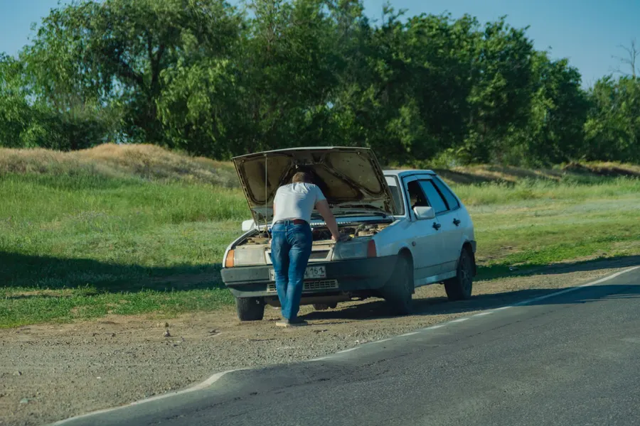 maui roadside assistance breakdown Driver checking engine under the hood while waiting for a towing service in Maui